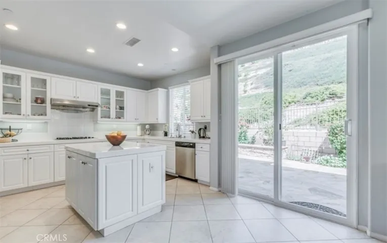 View of kitchen showing glass slider door to backyard.  There is a lot of natural light!