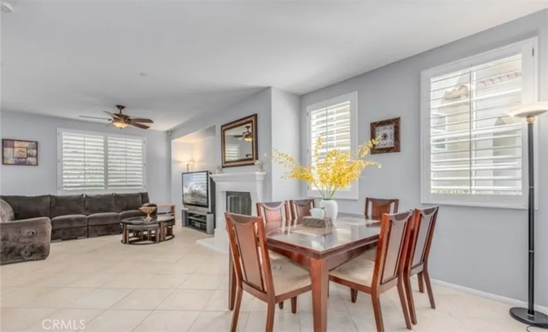 Downstairs dining and living areas separated by fireplace.