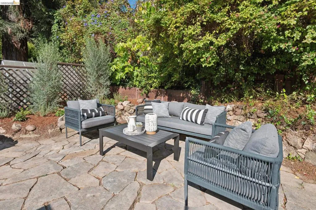 Flagstone patio with a trellised fence and lush perimeter landscaping Flagstone patio with a trellised fence and lush perimeter landscaping