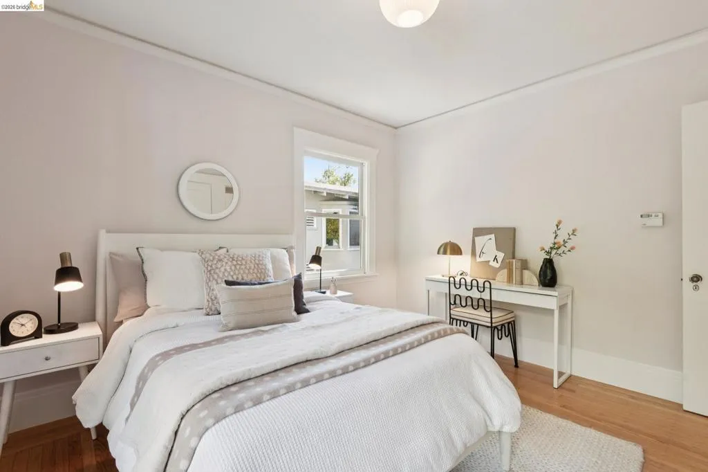 Hardwood flooring, painted walls, window with trim, and a ceiling-mounted light fixture Hardwood flooring, painted walls, window with trim, and a ceiling-mounted light fixture