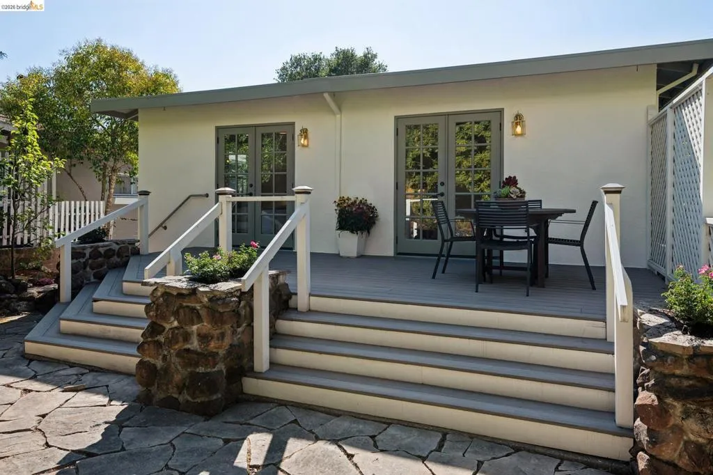 Spacious exterior deck with composite flooring and stone-clad stair bases Spacious exterior deck with composite flooring and stone-clad stair bases