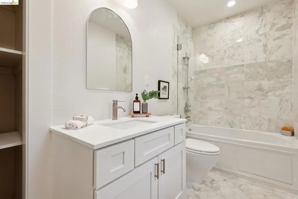 White vanity with a single basin, stainless steel faucet, and white countertop White vanity with a single basin, stainless steel faucet, and white countertop