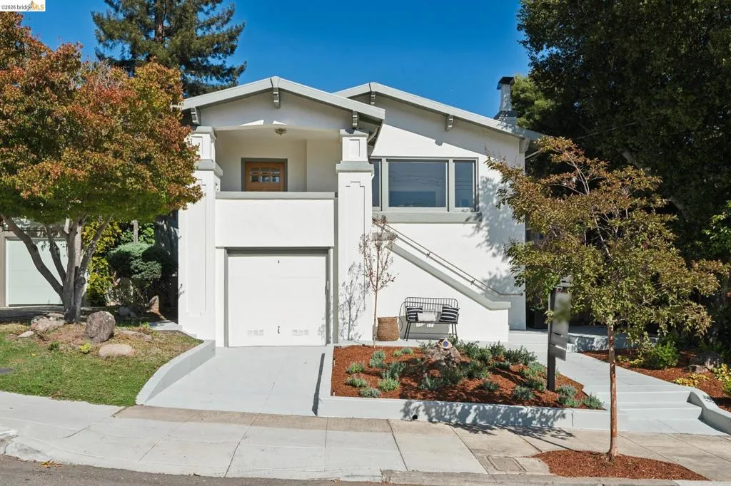 Two-story stucco exterior with an attached garage, upper-level entry, and a concrete driveway Two-story stucco exterior with an attached garage, upper-level entry, and a concrete driveway