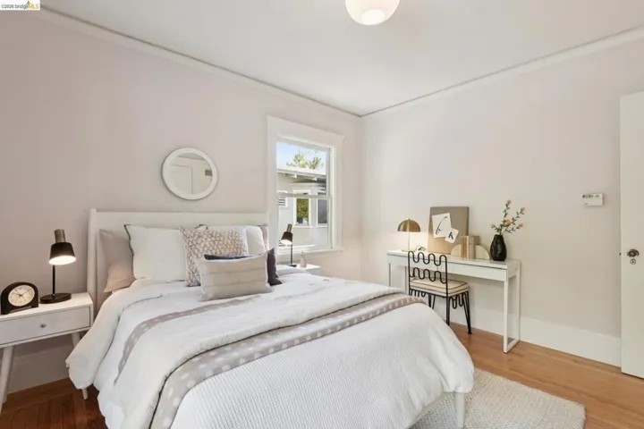 Hardwood flooring, painted walls, window with trim, and a ceiling-mounted light fixture