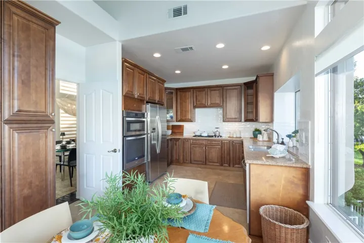 Remodeled Kitchen with expanse of cabinets on both ends w/new gleaming subway tile backsplash and granite counters