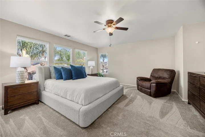 PRIMARY BEDROOM WITH NEW CEILING FAN AND NEW CARPET