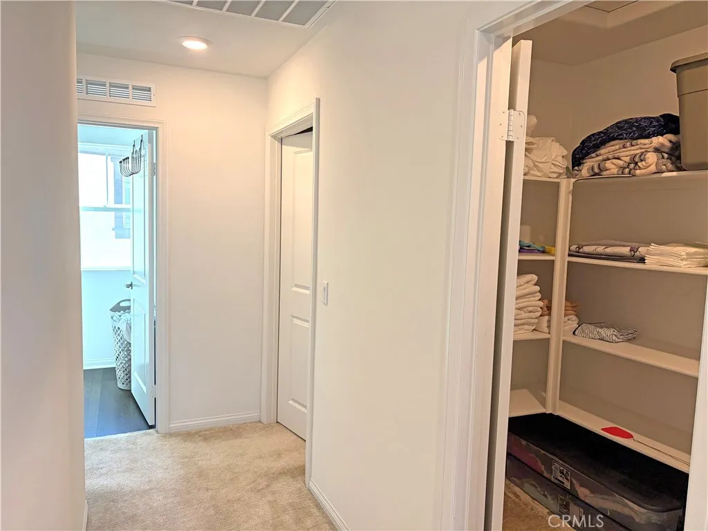 Upstairs Hall, walk-in linen closet and view to laundry