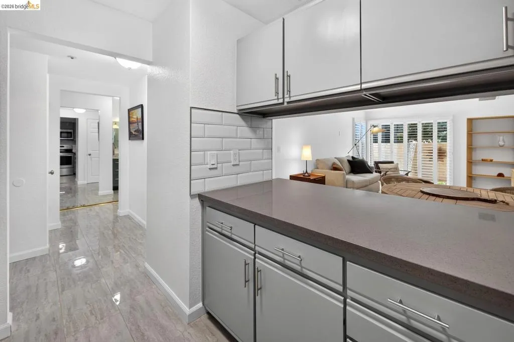 Kitchen pass-through with a solid surface countertop and subway tile backsplash Kitchen pass-through with a solid surface countertop and subway tile backsplash