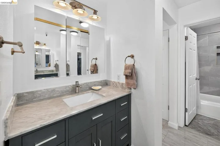 Vanity with an integrated sink, dual-door medicine cabinet, and overhead lighting