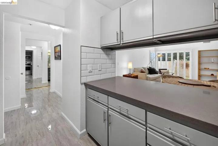 Kitchen pass-through with a solid surface countertop and subway tile backsplash