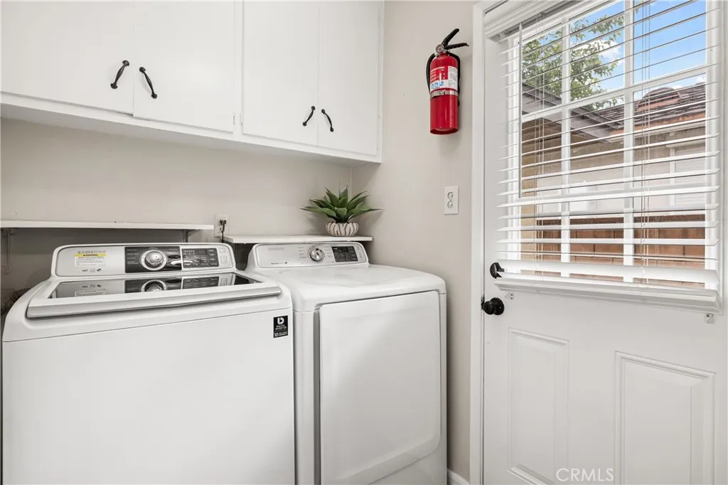 Dedicated indoor laundry room with washer and dryer, built-in cabinetry, storage and direct exterior access. Dedicated indoor laundry room with washer and dryer, built-in cabinetry, storage and direct exterior access.