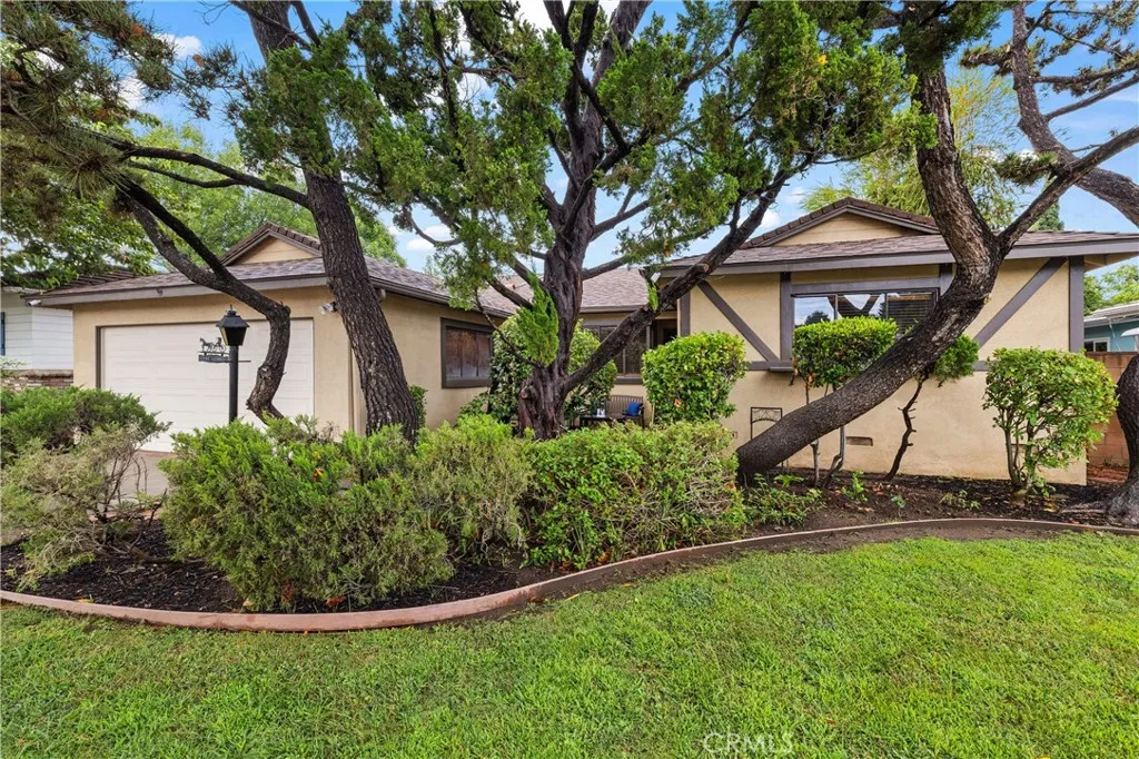 Welcoming front exterior framed by mature shade trees and lush landscaping, creating a private and inviting approach to the home. Welcoming front exterior framed by mature shade trees and lush landscaping, creating a private and inviting approach to the home.
