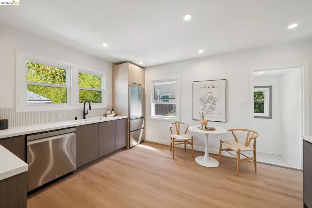 Kitchen featuring stainless steel appliances, wood-finish flooring, white countertops, and recessed lighting