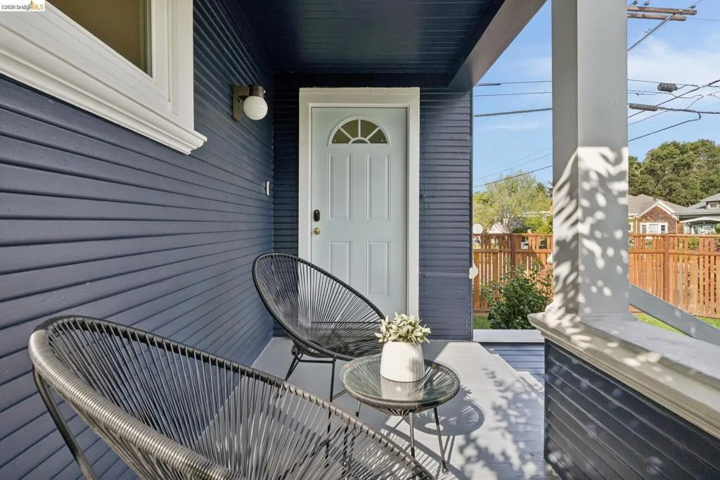 Porch with blue horizontal siding, a new 'ocean air' painted entry door with and a white window.