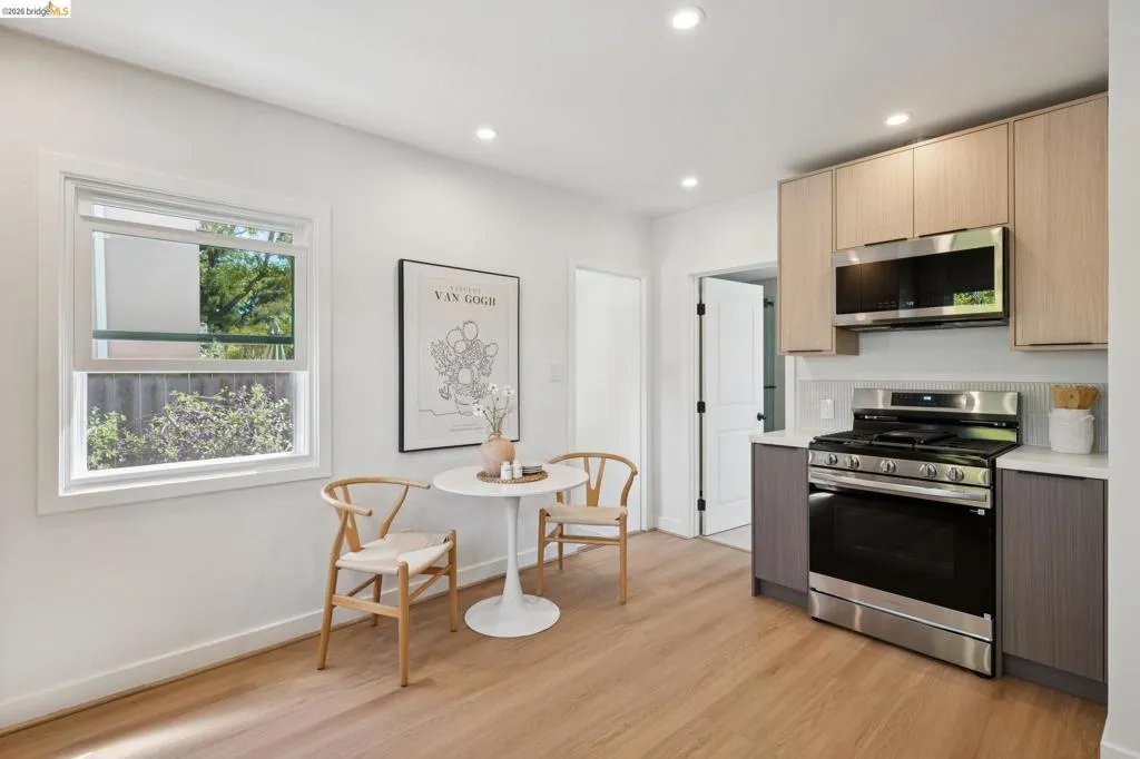 Wood-finish flooring, recessed lighting, and a window with white trim