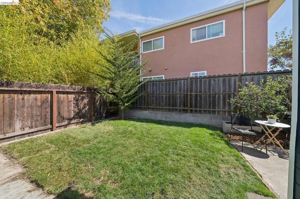 Grassed yard with wood fencing and concrete patio