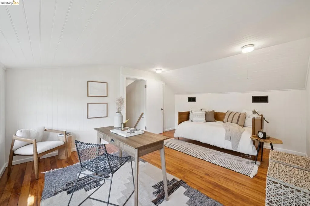 Wood-finish flooring with white paneled walls and a white paneled ceiling