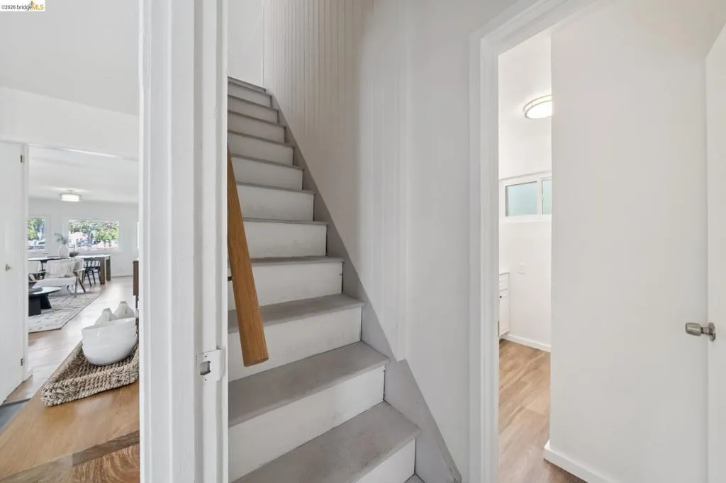 Staircase featuring a wood handrail