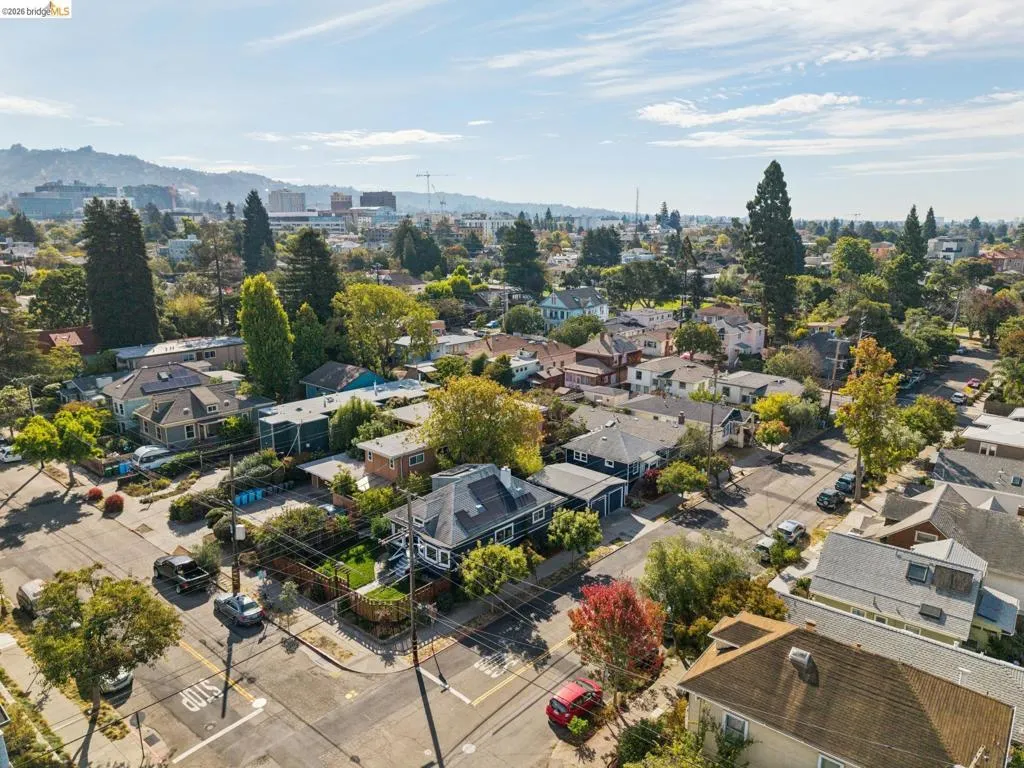 Aerial perspective showcasing a residential street with mature trees and a distant mountain range