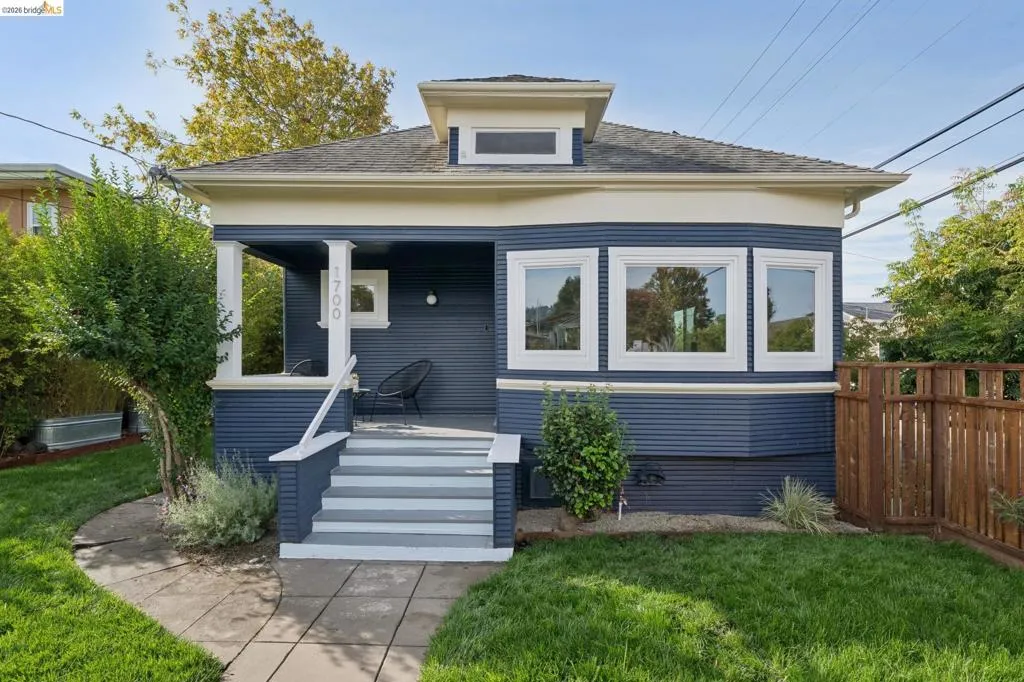 Craftsman-style exterior with a deep blue façade, white trim, and a welcoming front porch
