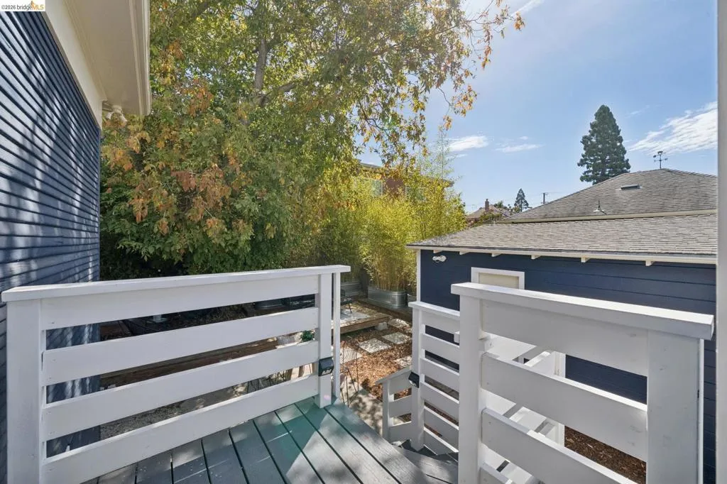 Deck with white painted railings and grey wood-finish flooring