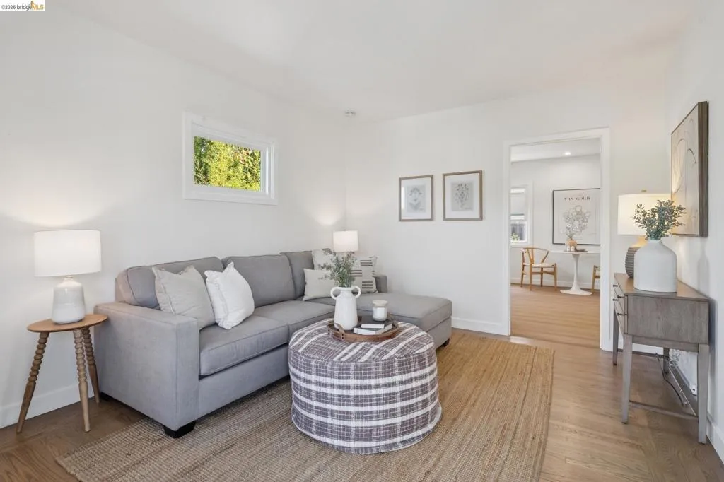 Hardwood-style flooring throughout, white walls, and a recessed window