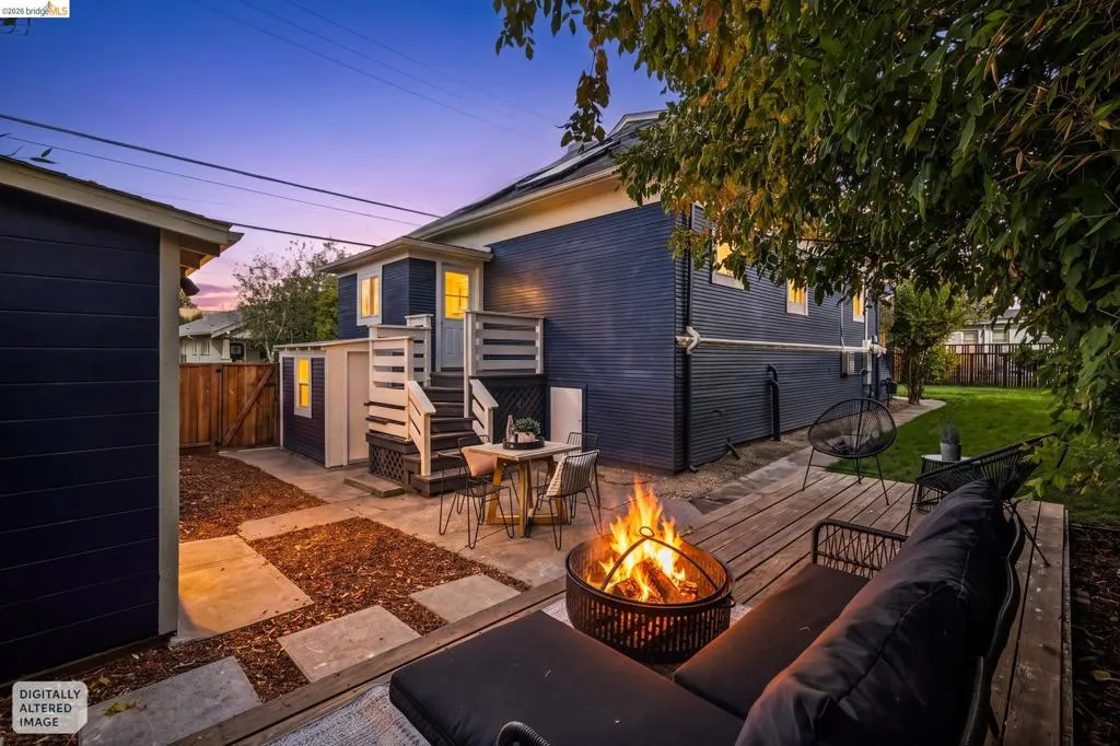 Expansive backyard featuring a wood deck, manicured lawn, and a paved patio area