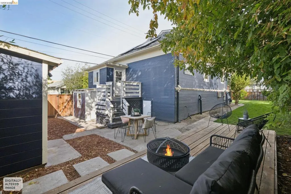 Backyard featuring an elevated wood deck, concrete patio, and a separate storage shed