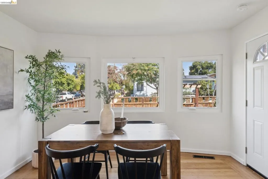 Bright interior with white walls, wood-finish flooring, and multiple windows providing natural light