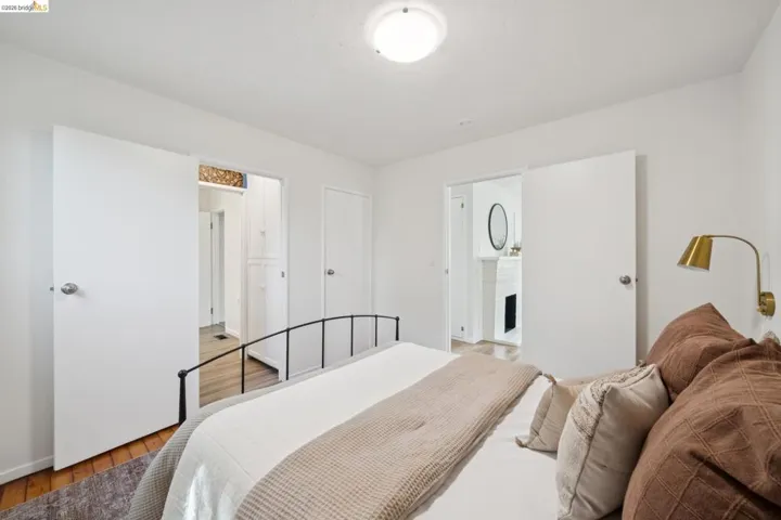 White walls, wood-finish flooring, and a flush-mount ceiling light