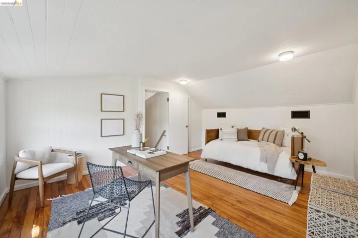Wood-finish flooring with white paneled walls and a white paneled ceiling