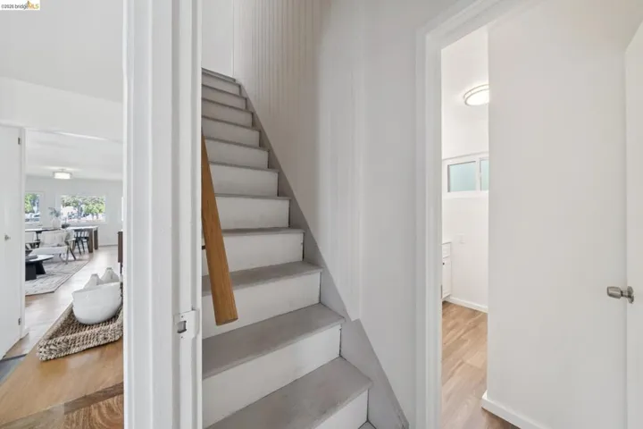Staircase featuring a wood handrail