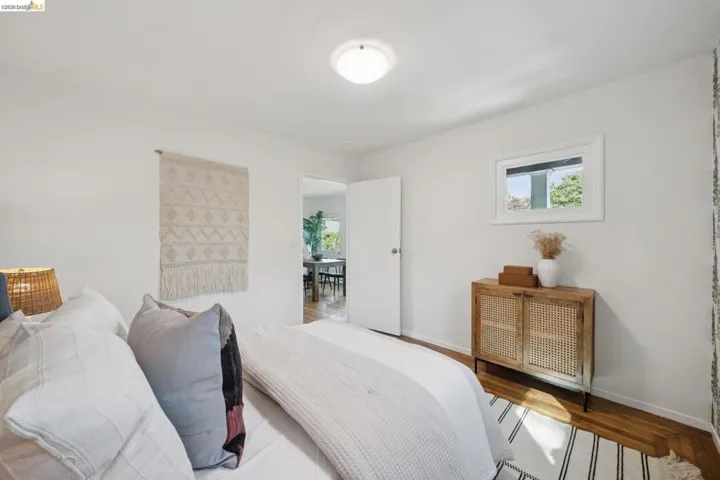 Wood-finish flooring, white walls, and a window with exterior views