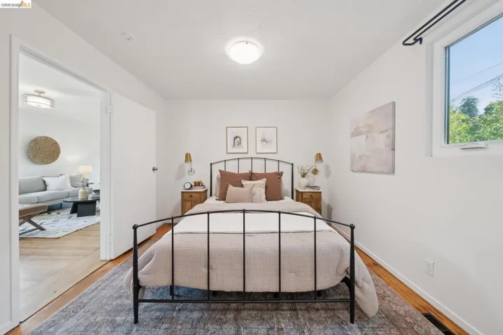Hardwood flooring, white walls, and a large window providing ample natural light
