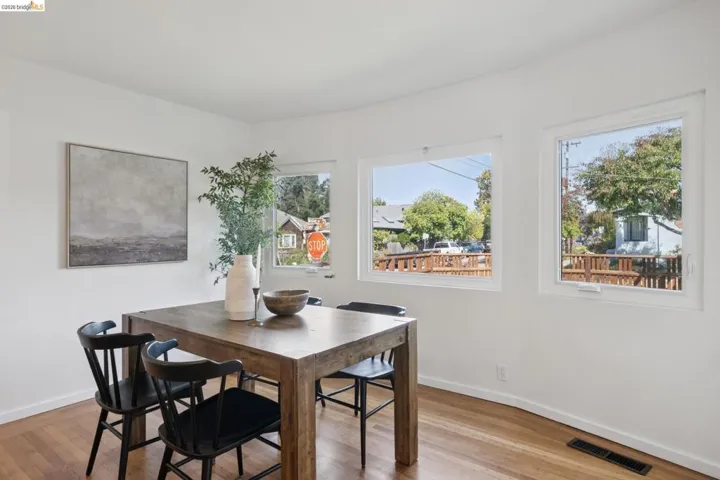 Light wood-finish flooring with white walls and multiple windows