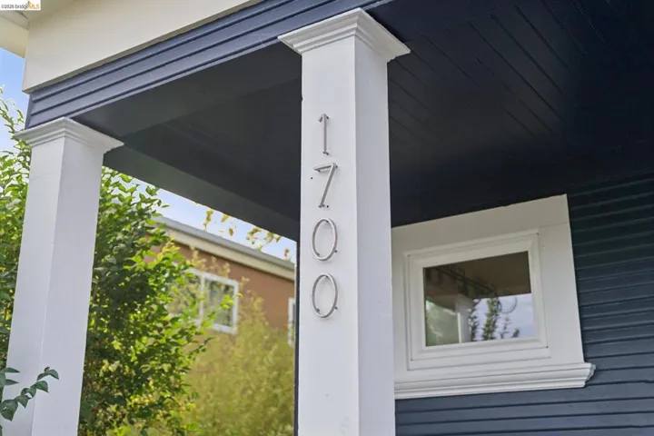 Front porch with white columns and contrasting dark blue siding