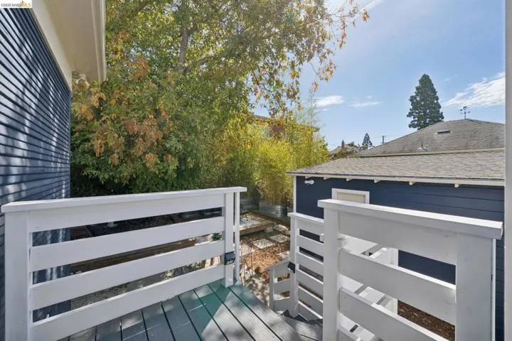 Deck with white painted railings and grey wood-finish flooring