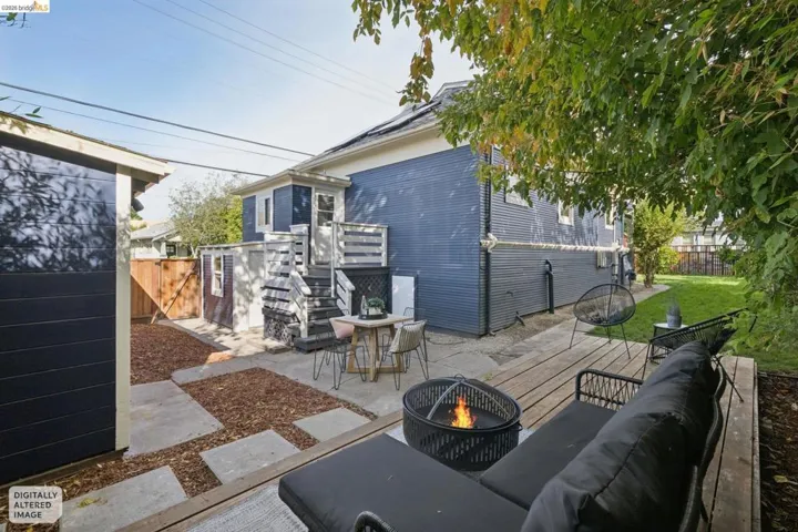 Backyard featuring an elevated wood deck, concrete patio, and a separate storage shed