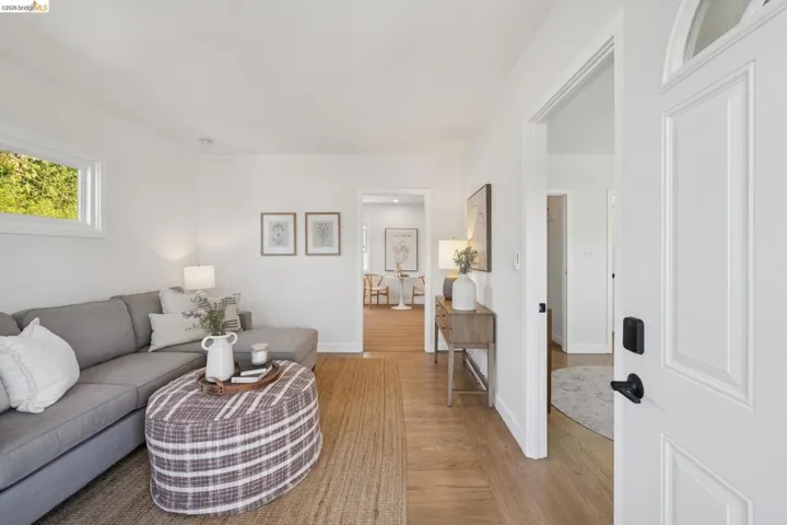 Wood-finish flooring throughout, white interior doors with matte black hardware, and crisp white walls