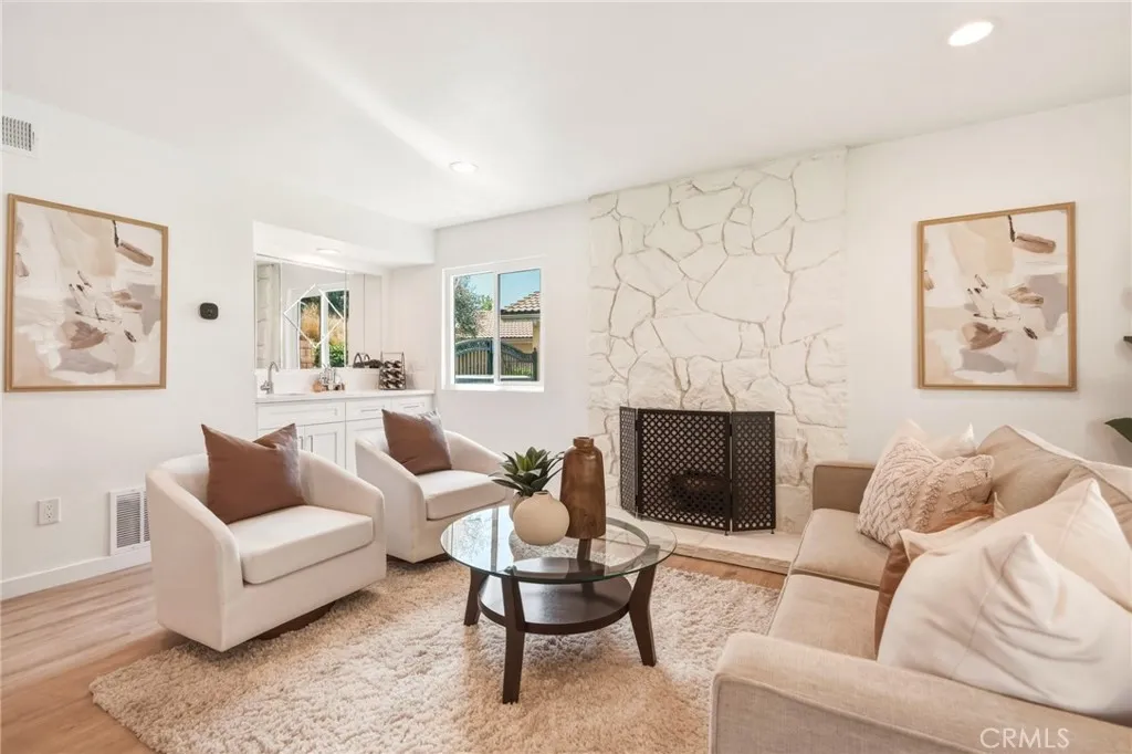 Family room with a stone fireplace and a built-in wet bar