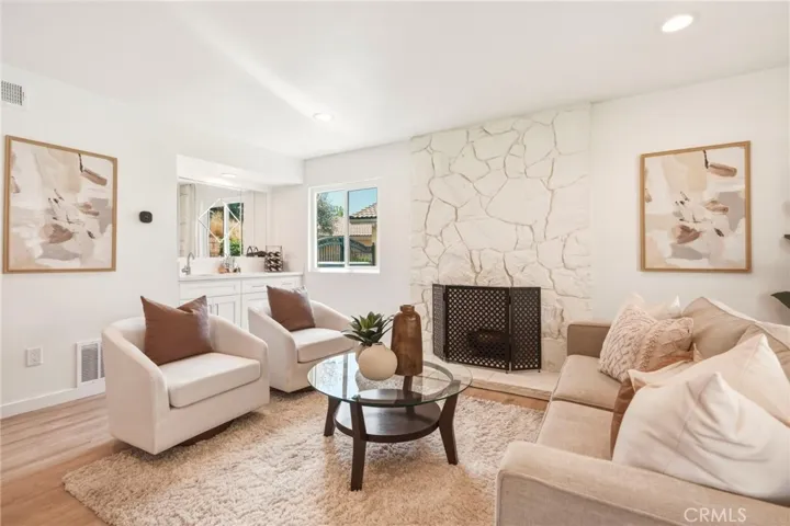 Family room with a stone fireplace and a built-in wet bar