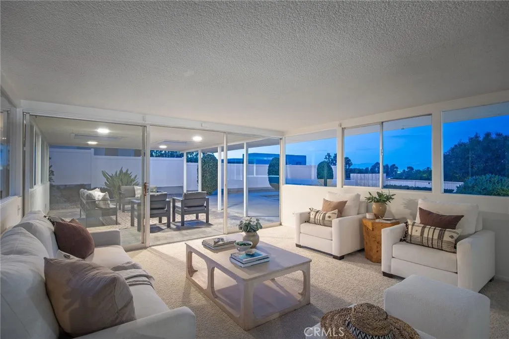Living room panel of windows to pool, patio and yard