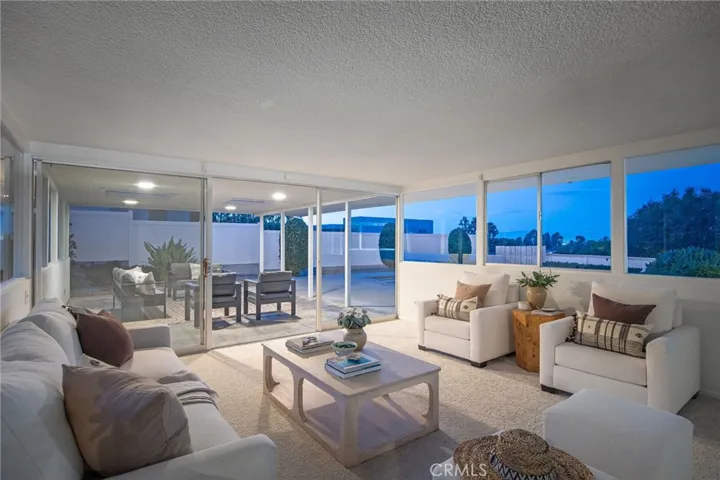 Living room panel of windows to pool, patio and yard