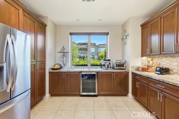 Built-in wine refrigerator and generous cabinetry provide convenient storage and functionality.
