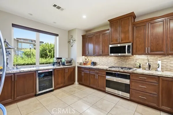Bright kitchen with garden views, warm wood finishes, and a decorative tile backsplash.