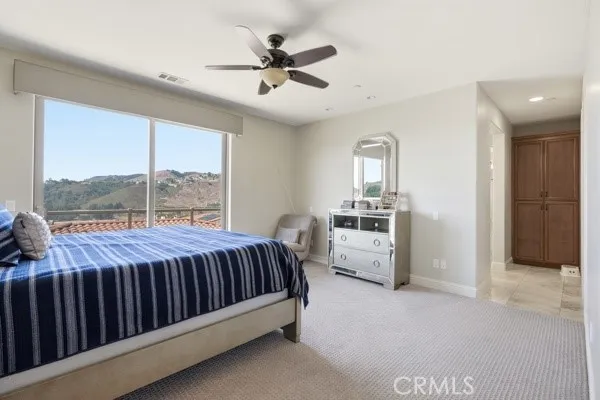 Bright primary suite with serene hillside views and direct access to the en-suite bathroom.