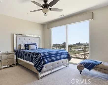 Main-floor primary bedroom featuring expansive sliding door and beautiful scenic views.