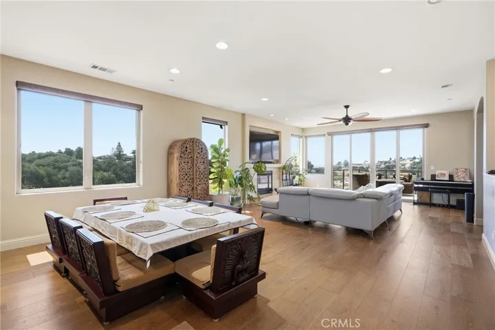 Open-concept dinning and living areas with abundant natural light, scenic views, and seamless access to the balcony.