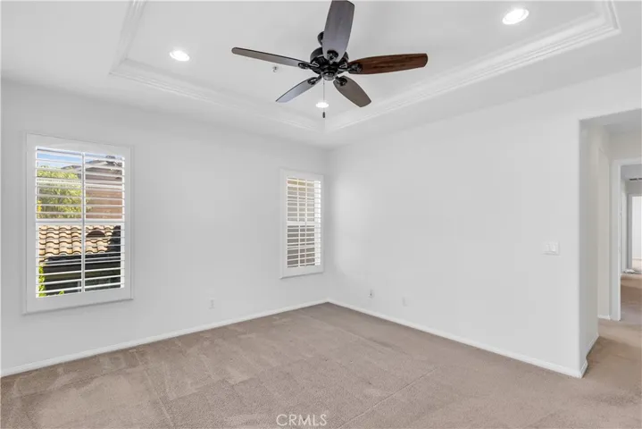 Master bedroom with plantation shutters, recessed lighting, ceiling fan