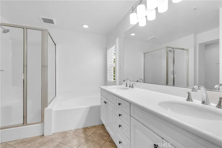 Master Bathroom with dual vanities, seperate bathtub + step-in shower.\